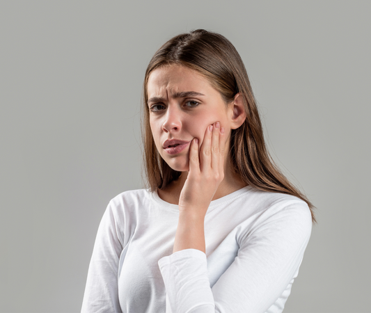 sensitive teeth featured image woman holding jaw